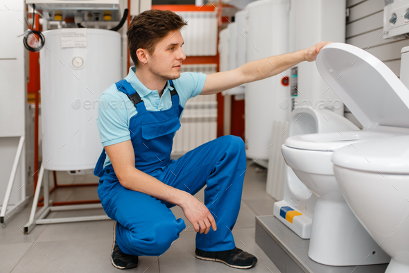 Plumber choosing the toilet in plumbering store