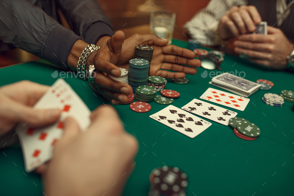 Poker players hands, gaming table on background - Stock Photo - Images