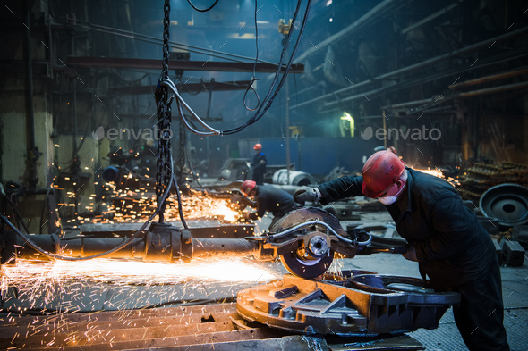 Male worker wearing special protective gloves, cutting metal with big electric grinder, orange - Stock Photo - Images