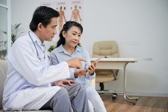 Asian Physician Consulting Senior Patient - Stock Photo - Images