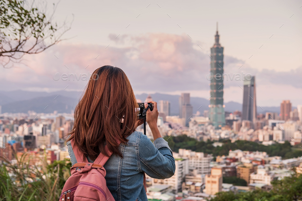 Young woman traveler taking photo of beautiful cityscape - Stock Photo - Images