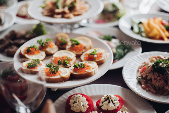 Banquet table served with various cold snacks and salads - Stock Photo - Images