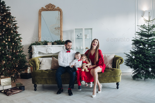 Happy festive family smiling posing at luxury december holiday interior at Christmas tree background - Stock Photo - Images