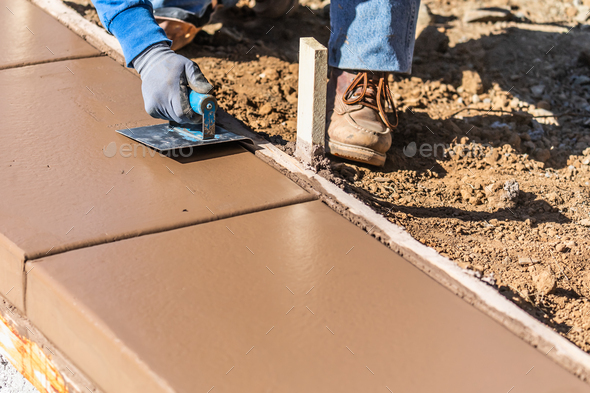 Construction Worker Using Stainless Steel Edger On Wet Cement Forming Coping Around New Pool - Stock Photo - Images