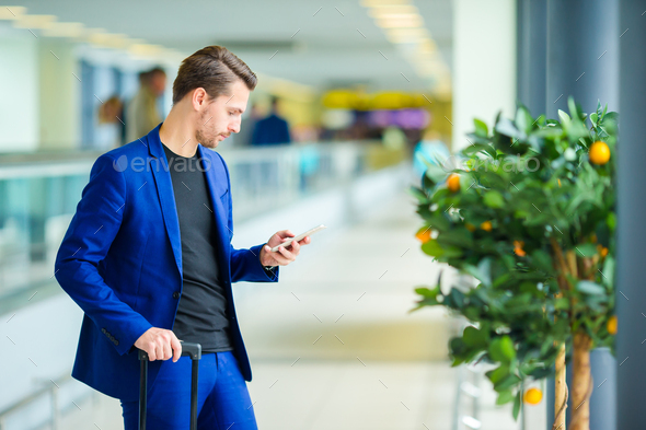 Young man in airport with baggage waiting boarding - Stock Photo - Images