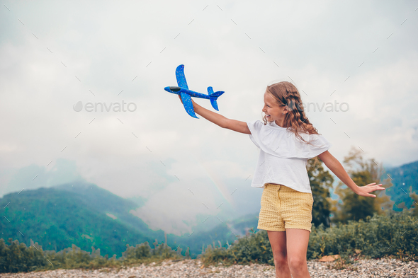 Beautiful happy little girl in mountains in the background of fog - Stock Photo - Images