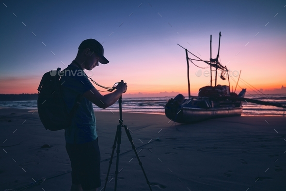 Photographer on beach at beautiful sunrise - Stock Photo - Images