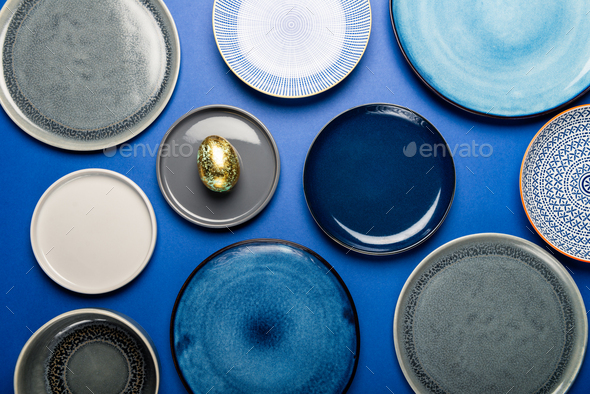 Different Plates with Easter Egg on blue background - Stock Photo - Images