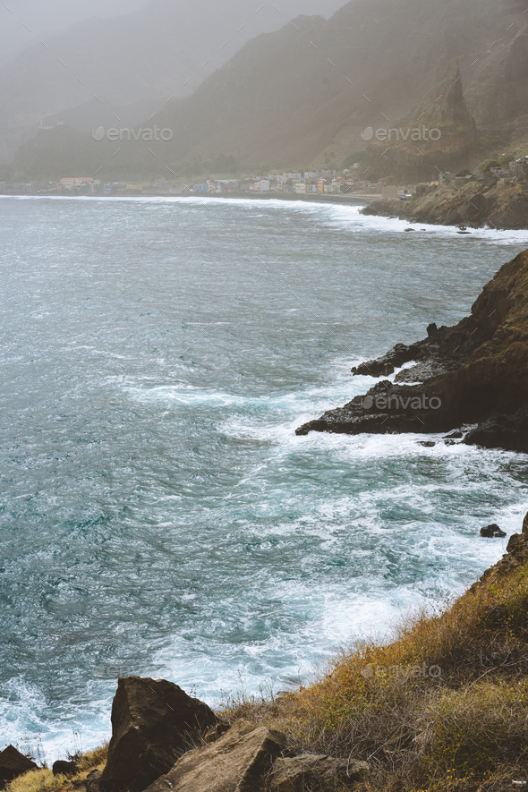 Rough ocean waves with blowing spray rolling onto the rocky volcanic shore. Paul Pombas place near - Stock Photo - Images