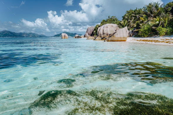 Well known beautiful Anse Source D'Argent beach with shallow blue lagoon and granite boulders - Stock Photo - Images