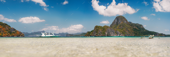 Cadlao island background with filippino traditional boats in shallow bay at El Nido bay from low - Stock Photo - Images