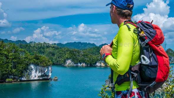 Traveler with Backpack enjoy the View over Roks in Kabui Bay near Waigeo. West Papuan, Raja Ampat - Stock Photo - Images