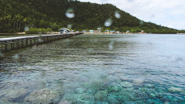 Wooden jetty near Yenbuba village leading to Mansuar island in Raja Ampat. Beautiful corals in - Stock Photo - Images