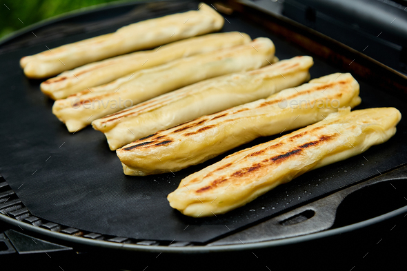 Grilled cheese puff pastry on the grill gas outdoor.