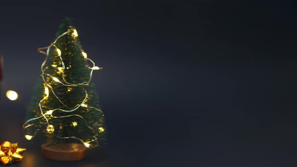 Colorful Gift Box with Golden Bow with Artificial Fir Tree and Christmas Decor alt