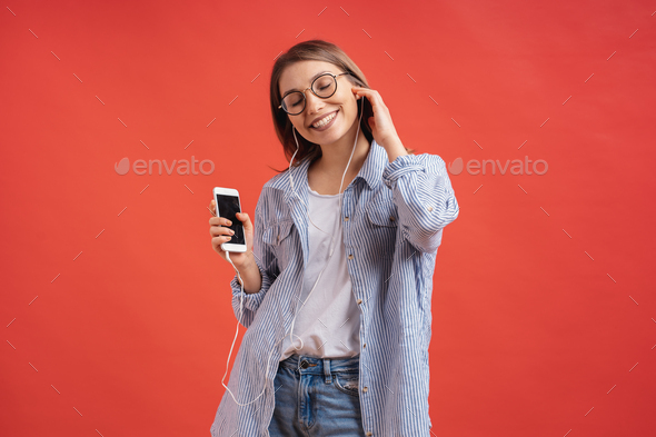 Smiling girl in casual clothes and earphones dancing moving hands. - Stock Photo - Images