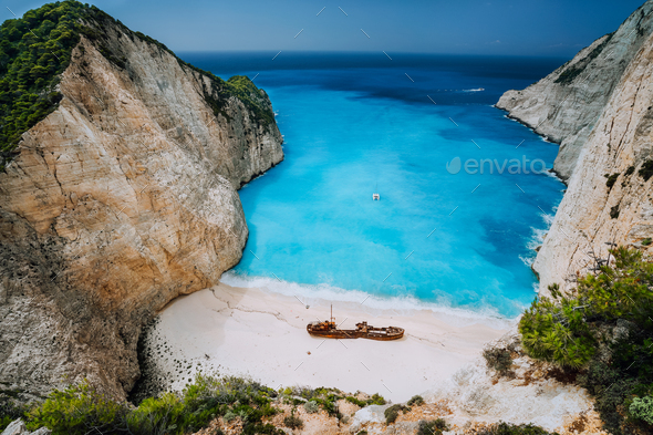 Epic view of Shipwreck middle of sandy Navagio beach surrounded by azure deep turquoise sea - Stock Photo - Images