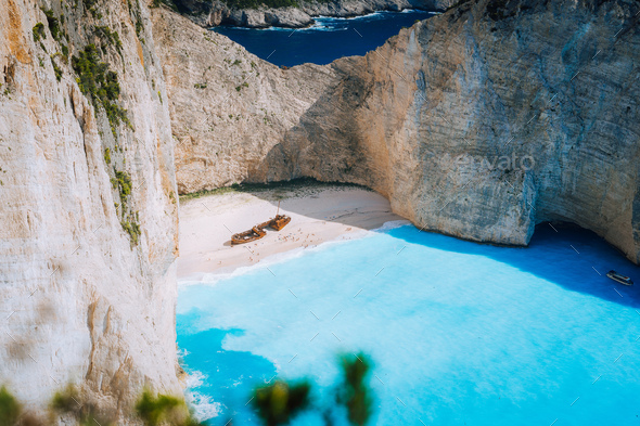 Famous shipwreck on Navagio beach with turquoise blue sea water surrounded by huge white cliffs - Stock Photo - Images