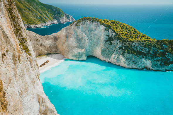 Famous shipwreck on Navagio beach with turquoise blue sea water surrounded by huge white cliffs - Stock Photo - Images