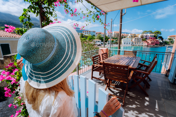 Assos village, Kefalonia, Greece. Female tourist in blue sunhat in front of cozy veranda terrace - Stock Photo - Images