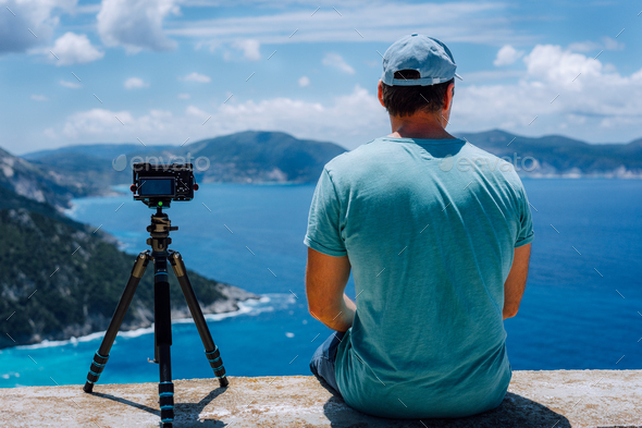 Travel Europe summer holiday in Greece. Happy man photographer enjoying cloudscape, coastline and - Stock Photo - Images