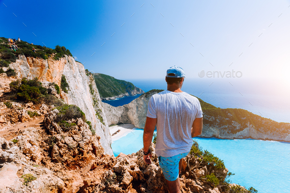 Male tourist enjoying spectacular view from the highs to Navagio beach on Zakynthos island - Stock Photo - Images