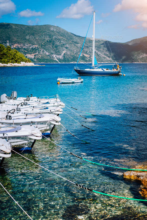 Small tourist boats for rent docked on the shore. Turquoise bay, crystal clear water. Amazing summer - Stock Photo - Images