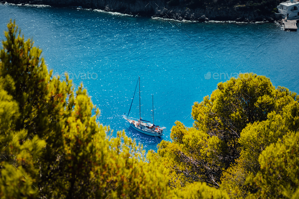 White yacht take a shelter in beautiful blue lagoon of Assos village Kefalonia. Frame between top of - Stock Photo - Images