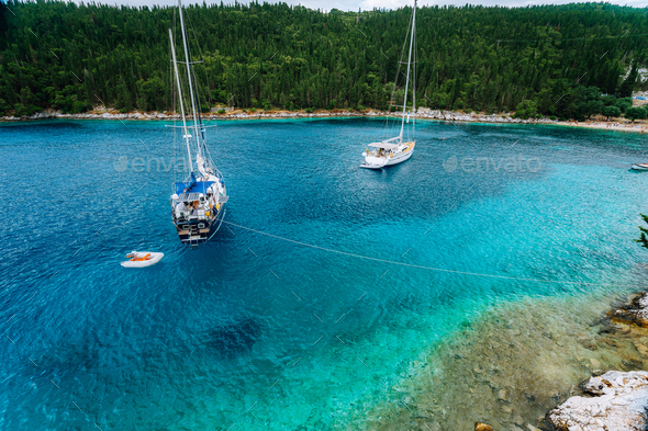 Crystal clear transparent blue turquoise teal mediterranean sea water of Foki Fiskardo Beach with - Stock Photo - Images