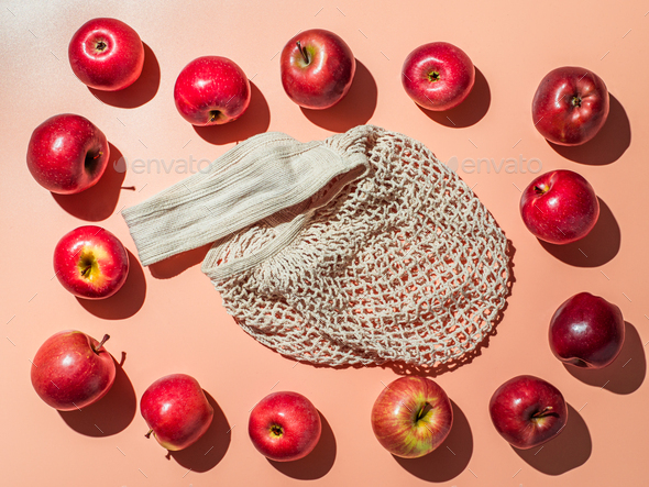 Textile string shopping bag and appes on orange bg - Stock Photo - Images