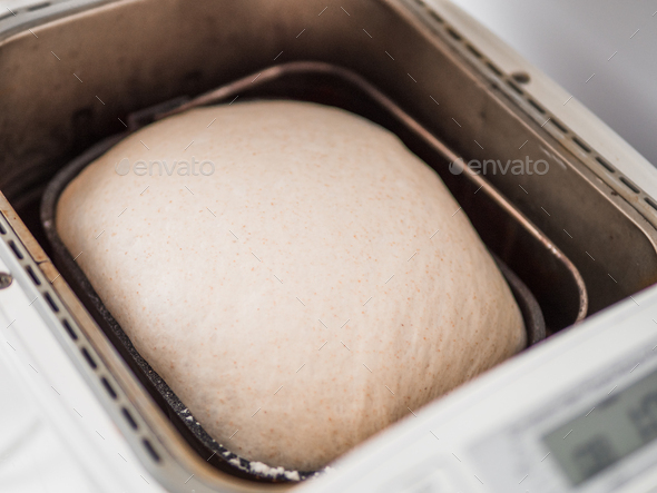Tasty sliced loaf and bread machine on table - Stock Photo - Images