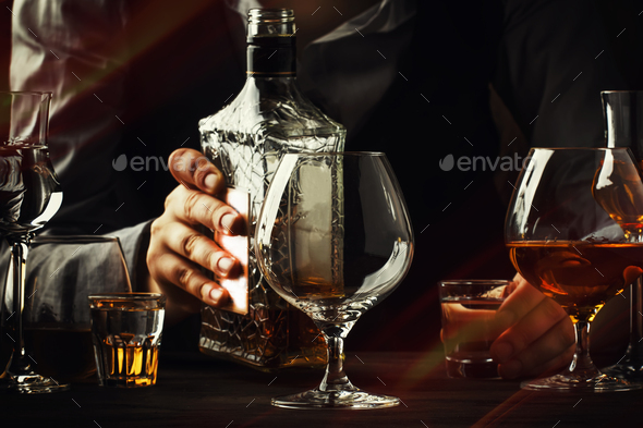 The bartender pours the cognac or brandy - Stock Photo - Images