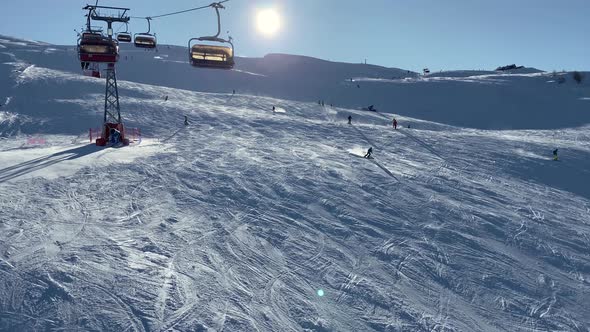 People skiing on snowy slope at ski resort in the mountains