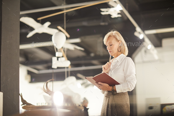 Female Art Gallery Manager Reading Book - Stock Photo - Images