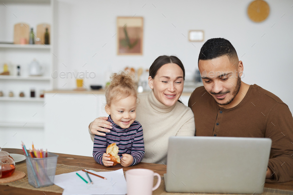 Happy Mixed-Race Family Using Laptop at Home - Stock Photo - Images