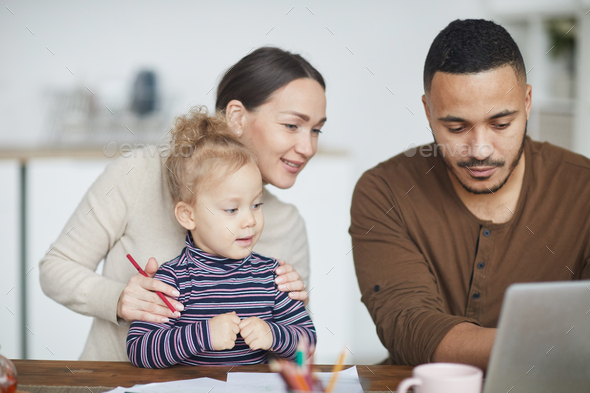 Mixed-Race Family Using Laptop at Home - Stock Photo - Images
