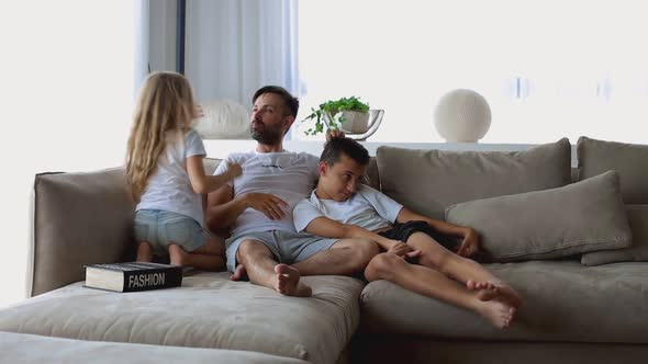 Two Cute Little Children Kissing Dad on Cheeks Congratulating with Father's Day Happy Loving Daddy