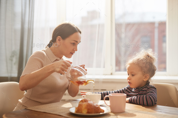 Loving Mother Enjoying Breakfast with Cute Little Daughter - Stock Photo - Images