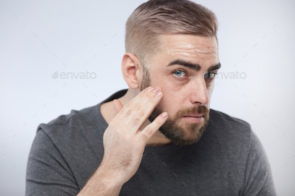 Confident Man Using Skincare Product - Stock Photo - Images