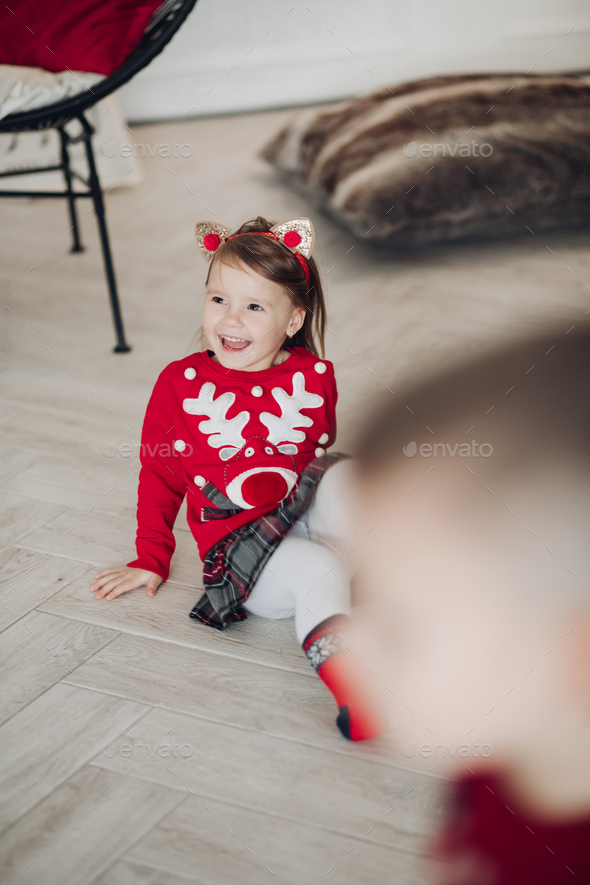 Lovely little girl in red dress with Christmas present - Stock Photo - Images