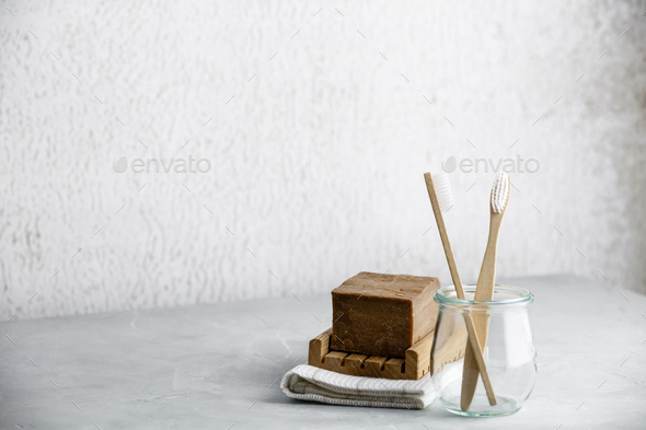 Eco-friendly bamboo toothbrushes in a glass jar and handmade organic soap, copy space - Stock Photo - Images