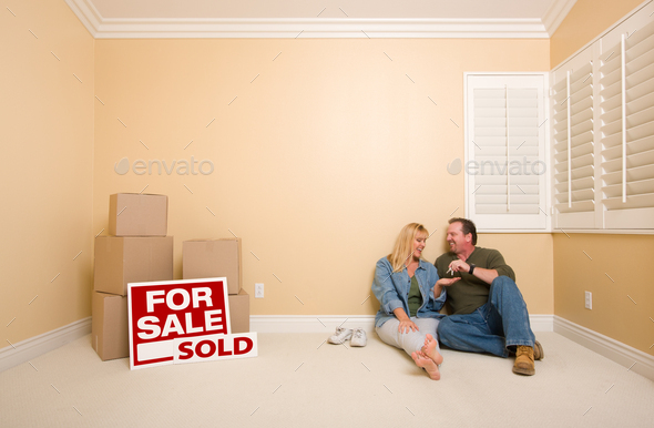 Couple on Floor Near Boxes and Sold Real Estate Signs - Stock Photo - Images