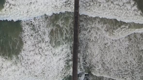 High Angle View of Drone Flying Over Pier with Waves Seen