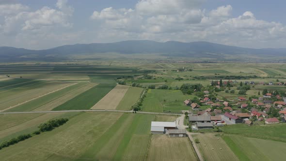 Farming Landscape Under Cloudy Sky Near Delnita, Romania. aerial alt