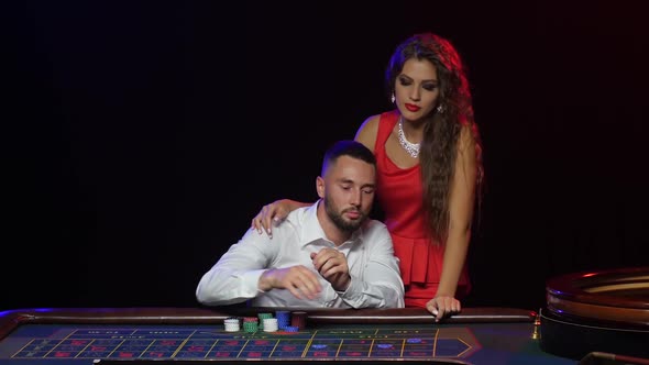 Man and Beautiful Girl in the Casino Wins in Roulette alt
