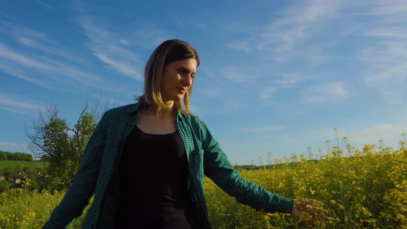 Successful Female Farmer Walks Through His Bloomed Rapeseed Field Bloomed alt