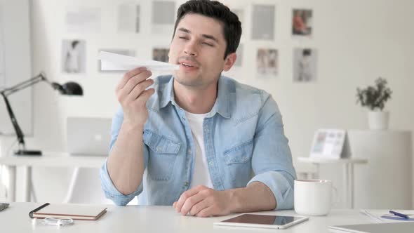 Thinking Positive Casual Young Man Holding Paper Plane alt