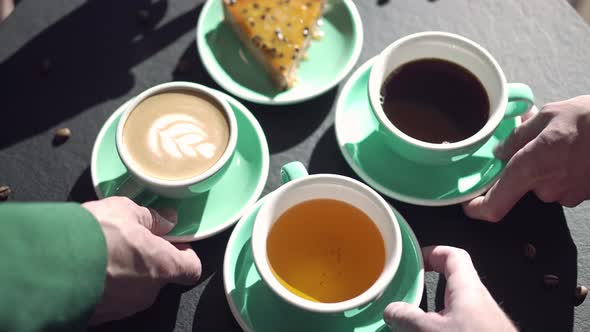 Top View of Table in Cafe with Hands Taking Tea and Coffee Cups and Dessert Plate in Slow Motion alt