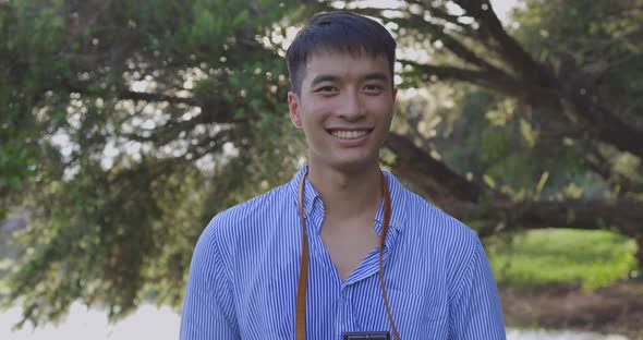 Happy Smiling Face Of Handsome Young Asian Man In The Park alt