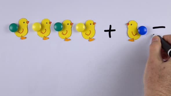 Figures of chicks from paper on the magnetic whiteboard, example of educational math children game